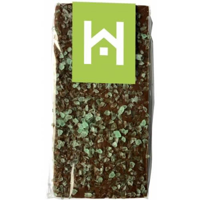A chocolate bar featuring dark chocolate topped with green peppermint crystals, packaged in a clear wrapper with branding.