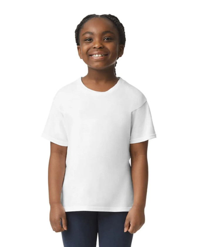 A young child smiles while wearing a white Gildan Youth Softstyle short sleeve T-shirt. The shirt has a logo.