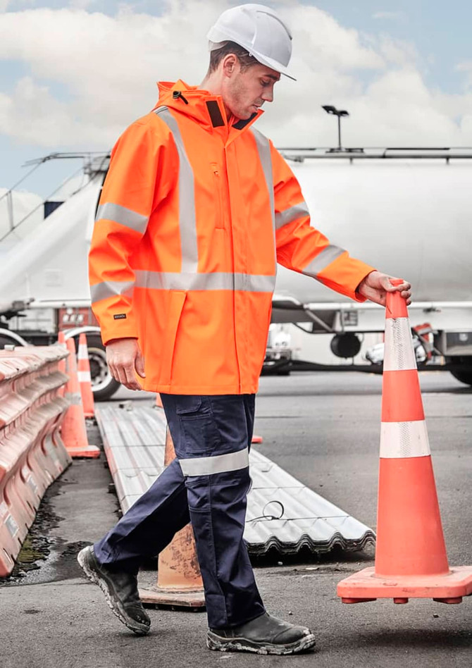 A heavy duty waterproof jacket in bright orange with reflective stripes, worn by a person in a construction environment.
