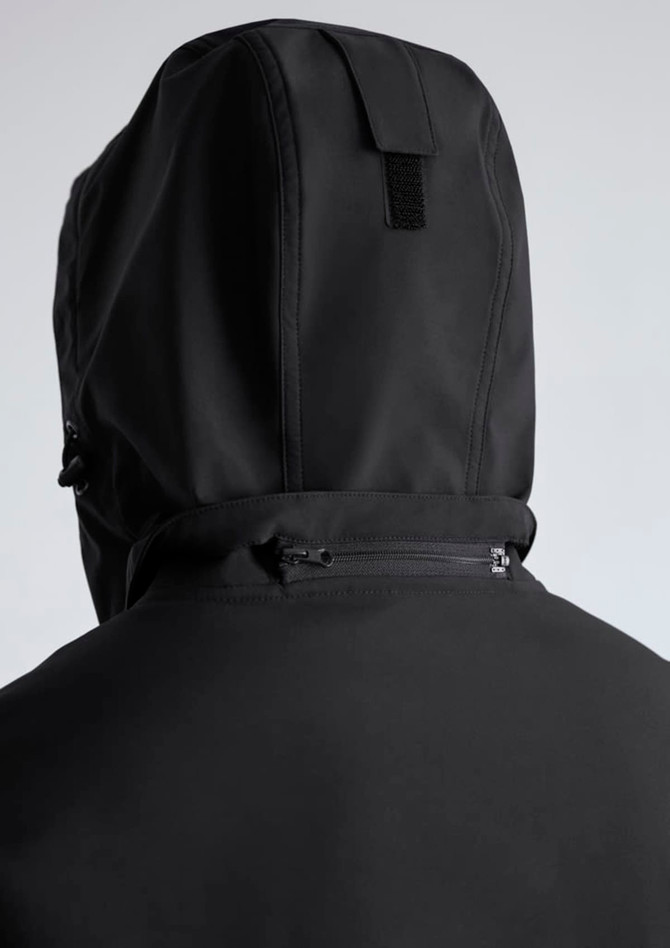 A black rain jacket featuring a hood and a rear zipper detail. The jacket includes branding.