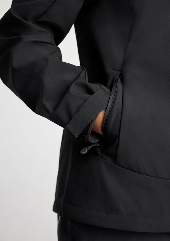 A black women's jacket with a close-up of the sleeve and pocket details, featuring a logo.