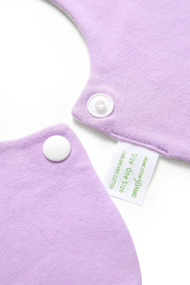 A lilac organic cotton baby bib featuring snap fasteners and a tag. Soft interlock fabric, 200gsm weight.