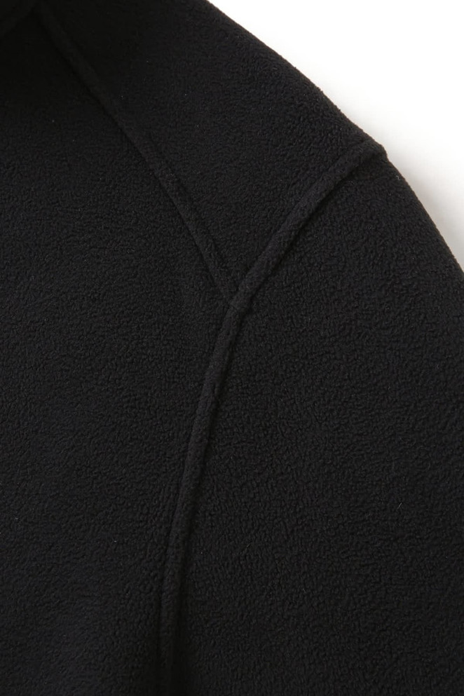 A black polar fleece half zip top featuring a soft texture and a subtle logo.