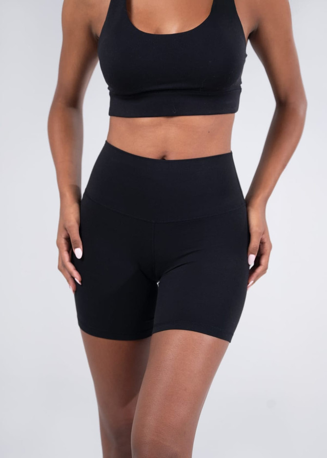 Black women's high rise legging shorts with a fitted design, featuring a smooth waistband and minimal branding.