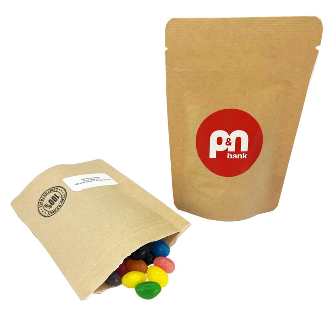 A compostable bag filled with colourful mini jelly beans. The bag features a logo on the front.