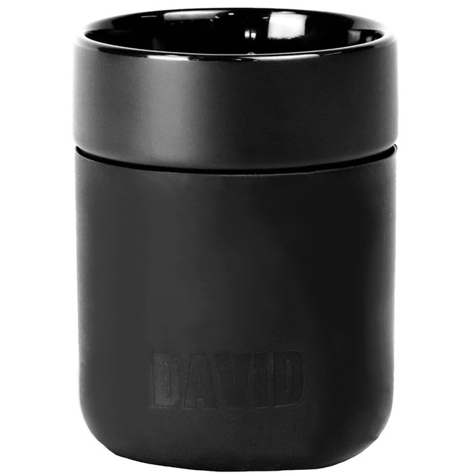A ceramic tumbler in black with a silicone wrap, featuring a logo on the surface.