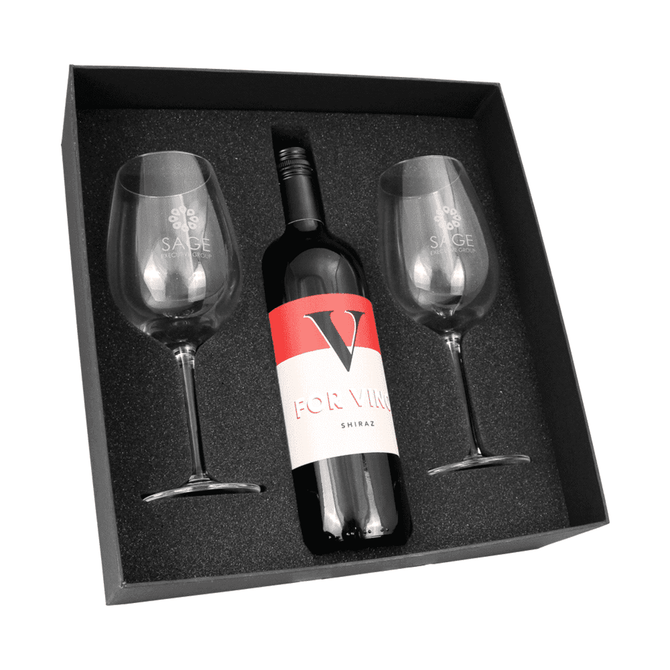 A wine box containing a bottle of Shiraz and two clear wine glasses, all set against a black foam base.