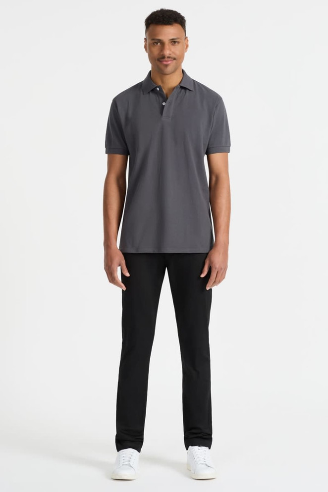A grey men's polo shirt displayed on a model, paired with black trousers and white shoes. It features a logo.