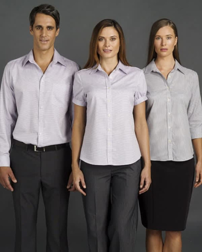 A button-up shirt in light purple, worn by a male and two females, showcasing short and long sleeve styles. It features a logo.