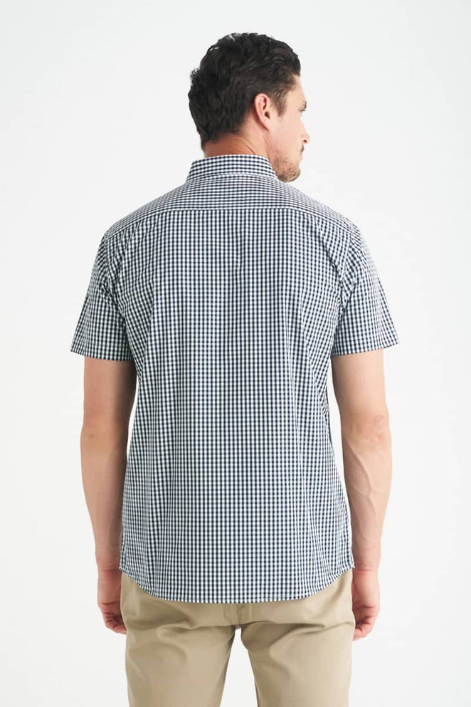 A man wearing a short sleeve button-up shirt with a checkered pattern in navy and white, viewed from the back.