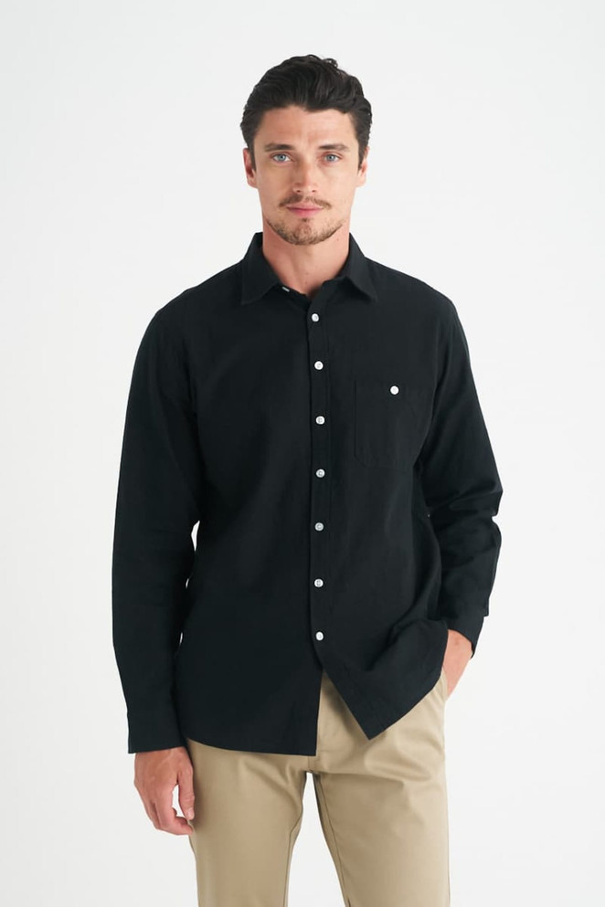 A men's long sleeve button-up shirt in black, featuring a single chest pocket and a logo.