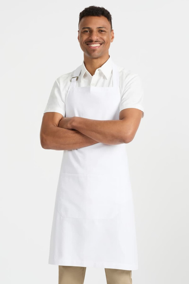 A man wearing a white short sleeve button-up shirt and a white apron, standing with arms crossed and smiling.