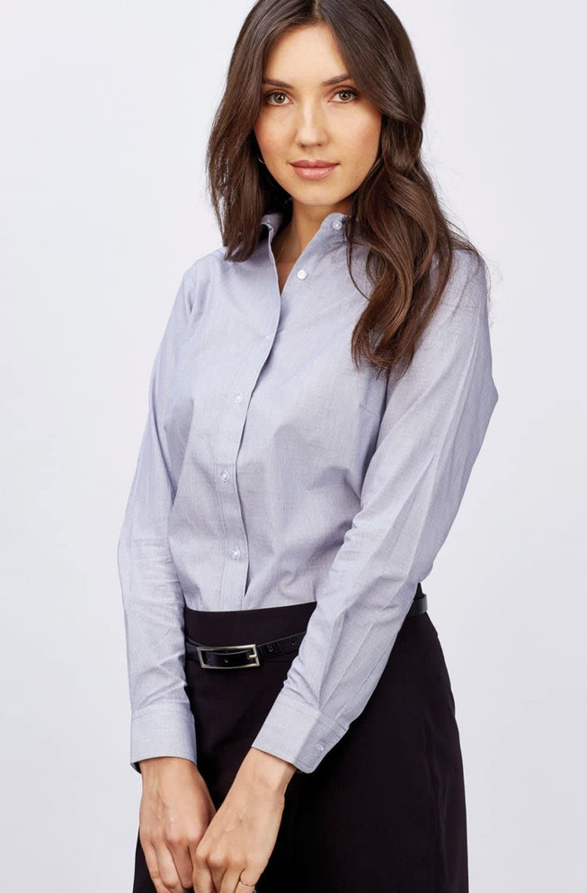 A button-up shirt in light blue, featuring long sleeves and a collar, worn by a woman with long hair.
