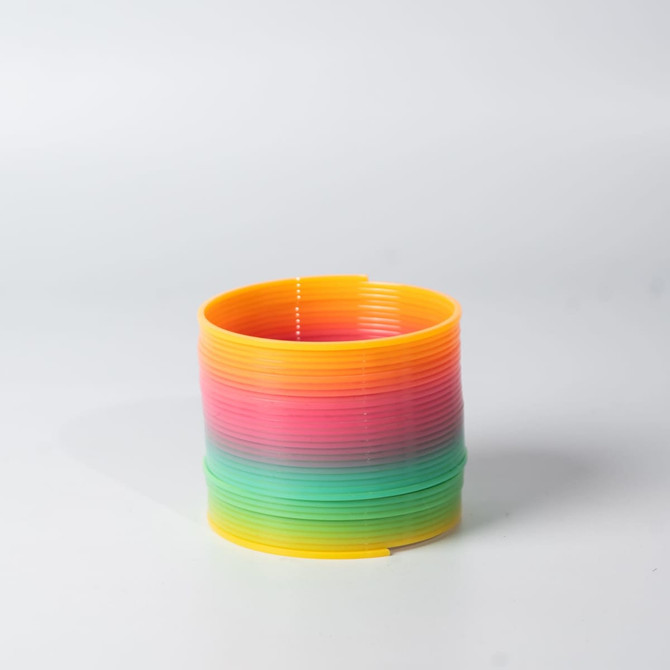A drink bottle in vibrant rainbow colours, featuring a blend of yellow, pink, and green, with a circular design.