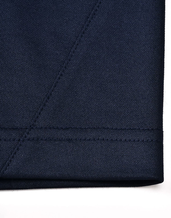 A close-up of a navy blue sustainable poly/cotton polo shirt, showcasing stitching and fabric texture.