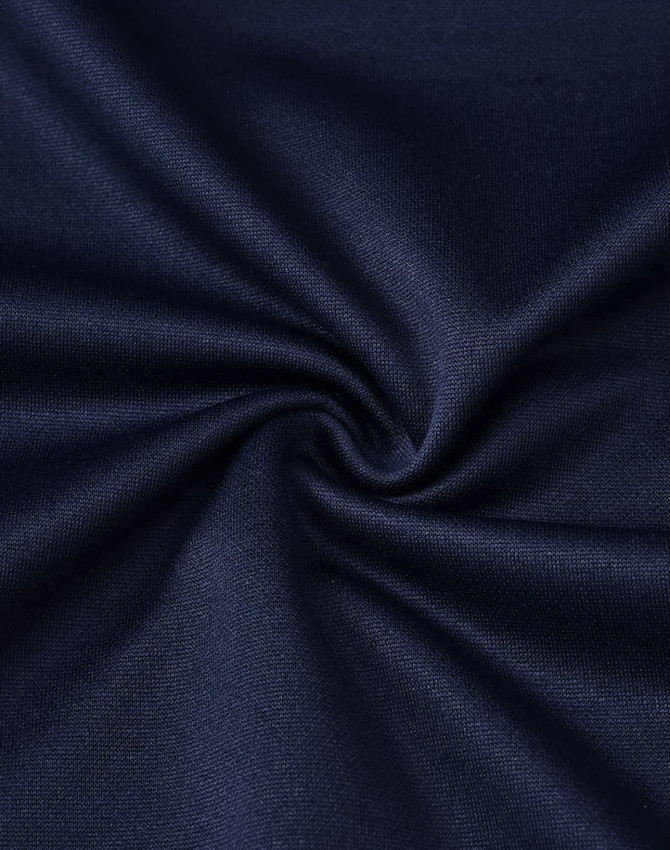 A close-up of dark navy fabric featuring a smooth texture, ideal for polo shirts, with soft, sustainable poly/cotton blend.
