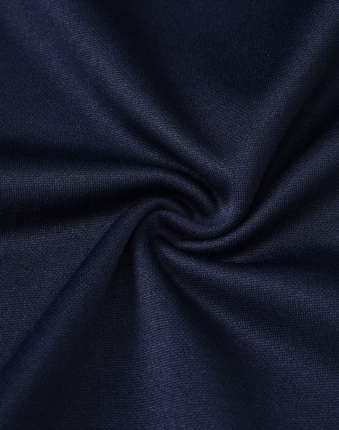 A close-up of dark navy fabric with a smooth texture, showcasing the sustainable poly/cotton blend.