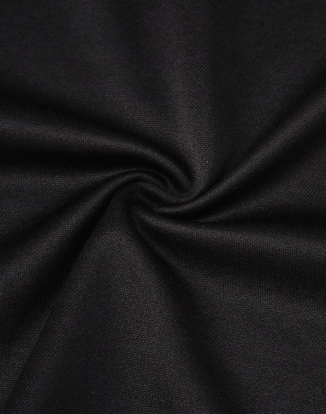 A close-up of black fabric with a smooth texture, showcasing its sustainable poly/cotton blend.