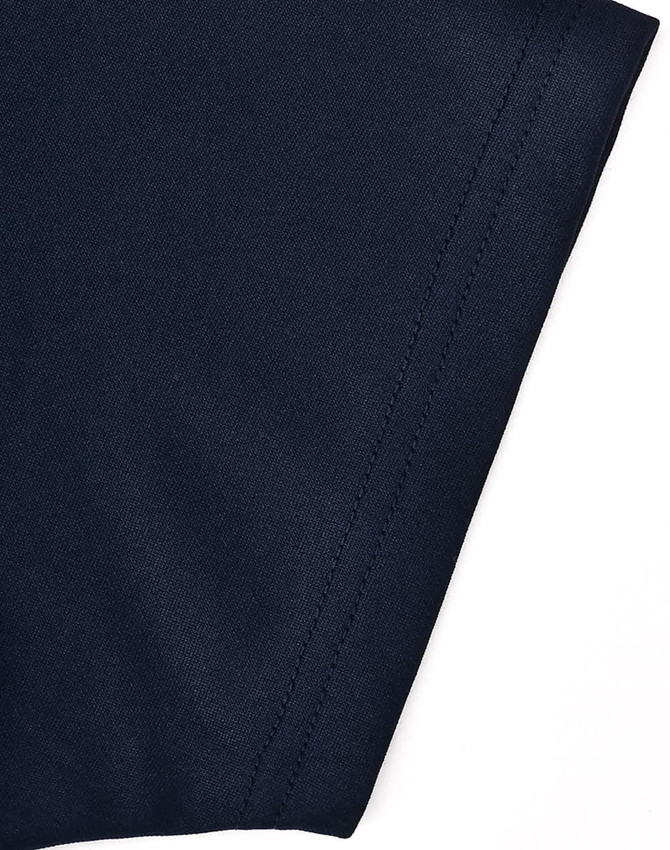 A close-up of a navy polo shirt featuring contrasting fabric texture and stitching details.