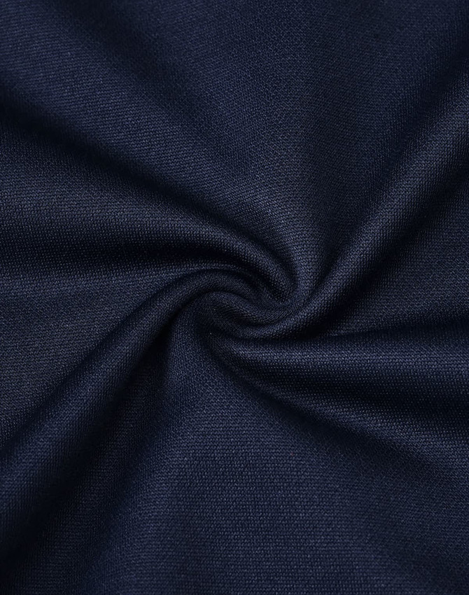 A close-up of navy fabric, showcasing its smooth texture and weave pattern, with a subtle swirl effect.