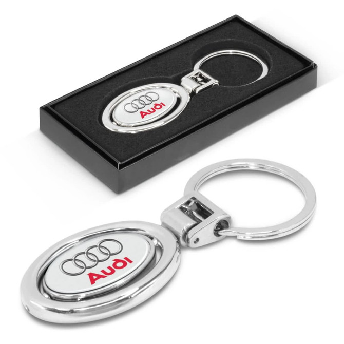 A metal key ring featuring an oval design with the Audi logo, packaged in a sleek black box.