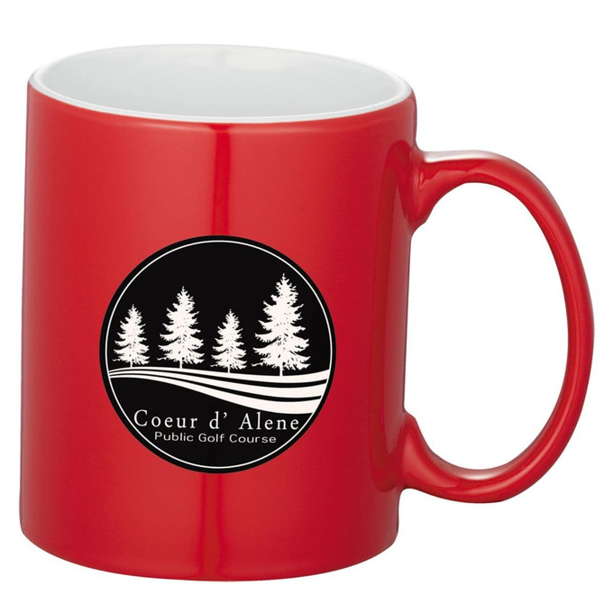 A red ceramic mug with a white interior and a logo featuring trees. Ideal for coffee or tea.