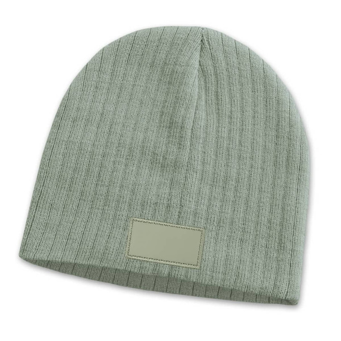 A green cable knit beanie featuring a patch. The design is textured and fitted for warmth.