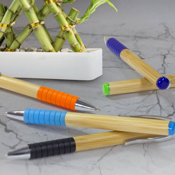 A set of Bamboo Twist Pens in various colours: orange, blue, green, and black, next to a bamboo arrangement.