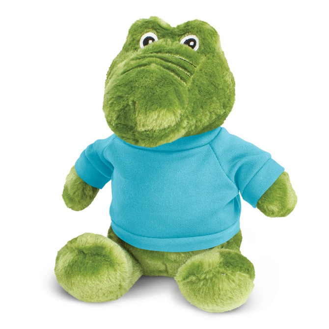 A green crocodile plush toy wearing a blue shirt, featuring large eyes and a soft texture.