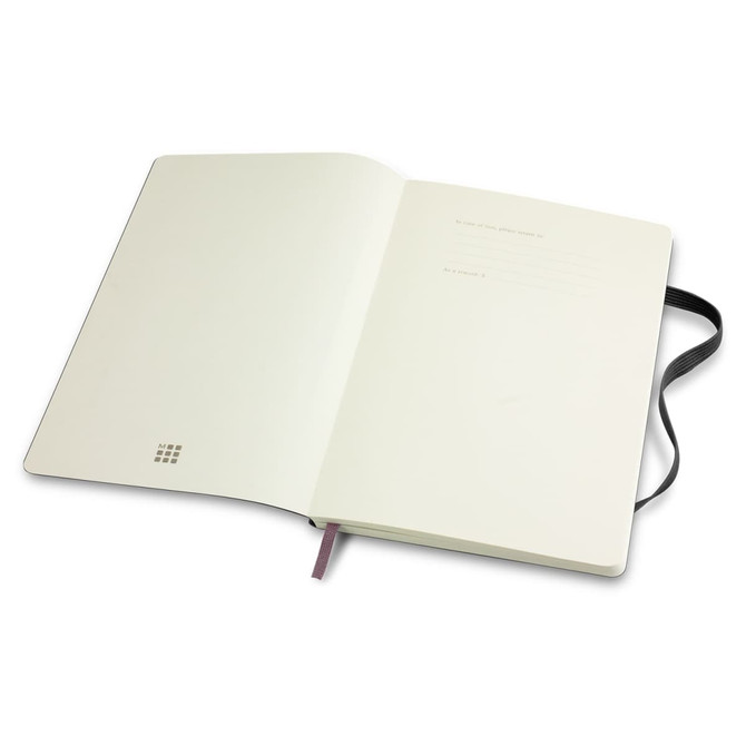 A large, soft-cover notebook in white with a black ribbon bookmark and an interior featuring blank pages. It has a logo.