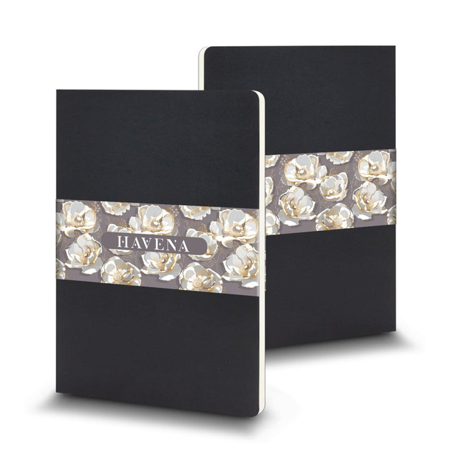 A large black Moleskine Volant journal featuring a floral design band. Includes a logo on the cover.