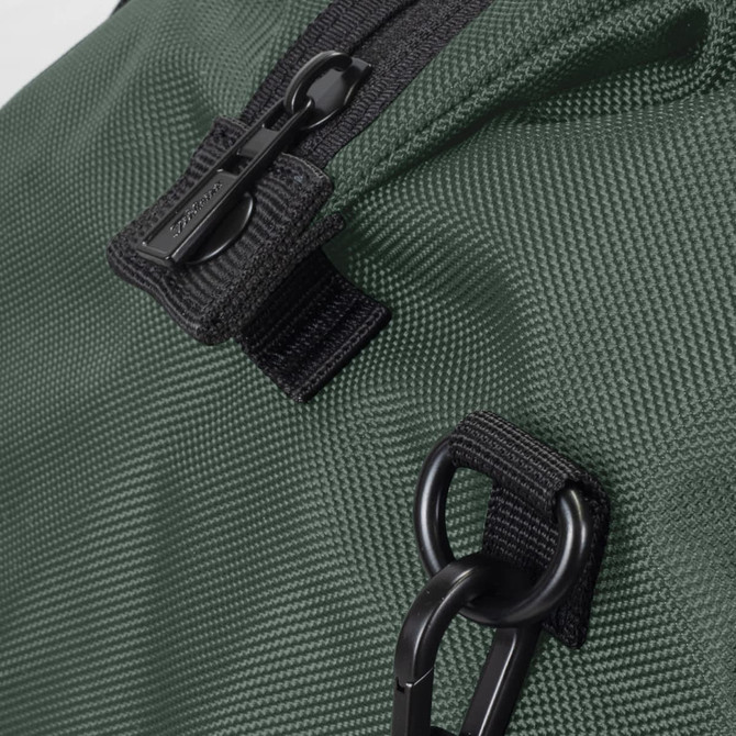 A close-up of a dark green duffle bag featuring a zipper and clip details, with a textured fabric finish.
