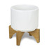 A white ceramic planter with a bamboo base, featuring a modern design and clean lines.
