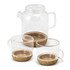 A glass teapot with two matching cups featuring cork bases, showcasing a clear and natural aesthetic.