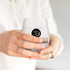 A stemless low ball glass in clear, held by a person, featuring a logo on the front.