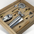 A cocktail set featuring stainless steel tools with wooden handles, neatly arranged in a brown box.