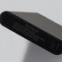 A black power bank with a sleek design, featuring various input and output specifications on the surface.