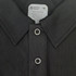 A black polo shirt featuring a collar and three buttons, labelled with care instructions and a brand logo.