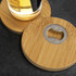 A drink bottle rests on two round bamboo coasters, each featuring a metal bottle opener in the centre.