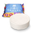 A round white compressed towel in front of colourful packaging featuring a logo.