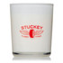 A glass candle with a white wax interior and a red logo featuring wings and a tyre motif.