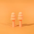 A pair of peach silicone earplugs on an orange background, designed for noise reduction, featuring a simple and smooth shape.