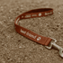 A brown dog leash with a metal clasp and a logo, featuring the text "best friend".