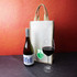 A jute double wine bag in natural colour alongside a bottle of wine and a glass of red wine. The bag has a logo.