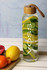 A drink bottle with a clear body, bamboo lid, and filled with sliced cucumber, lemon, and pomegranate. It features a logo.