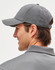 A grey 4-way stretch cap featuring laser cut ventilation, designed for comfort, with an adjustable strap and branding.
