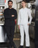 A pair of chefs wearing black and white functional chef pants, standing in a commercial kitchen setting.