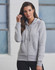 A grey full-zip fleecy hoodie featuring a hood and drawstrings, worn by a model. It includes a logo.