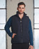 A heavy quilted vest in navy blue, featuring a front zip and side pockets, worn over a long-sleeve top.