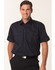 A men's short sleeve military shirt in navy with two front pockets and shoulder epaulettes, featuring a logo.